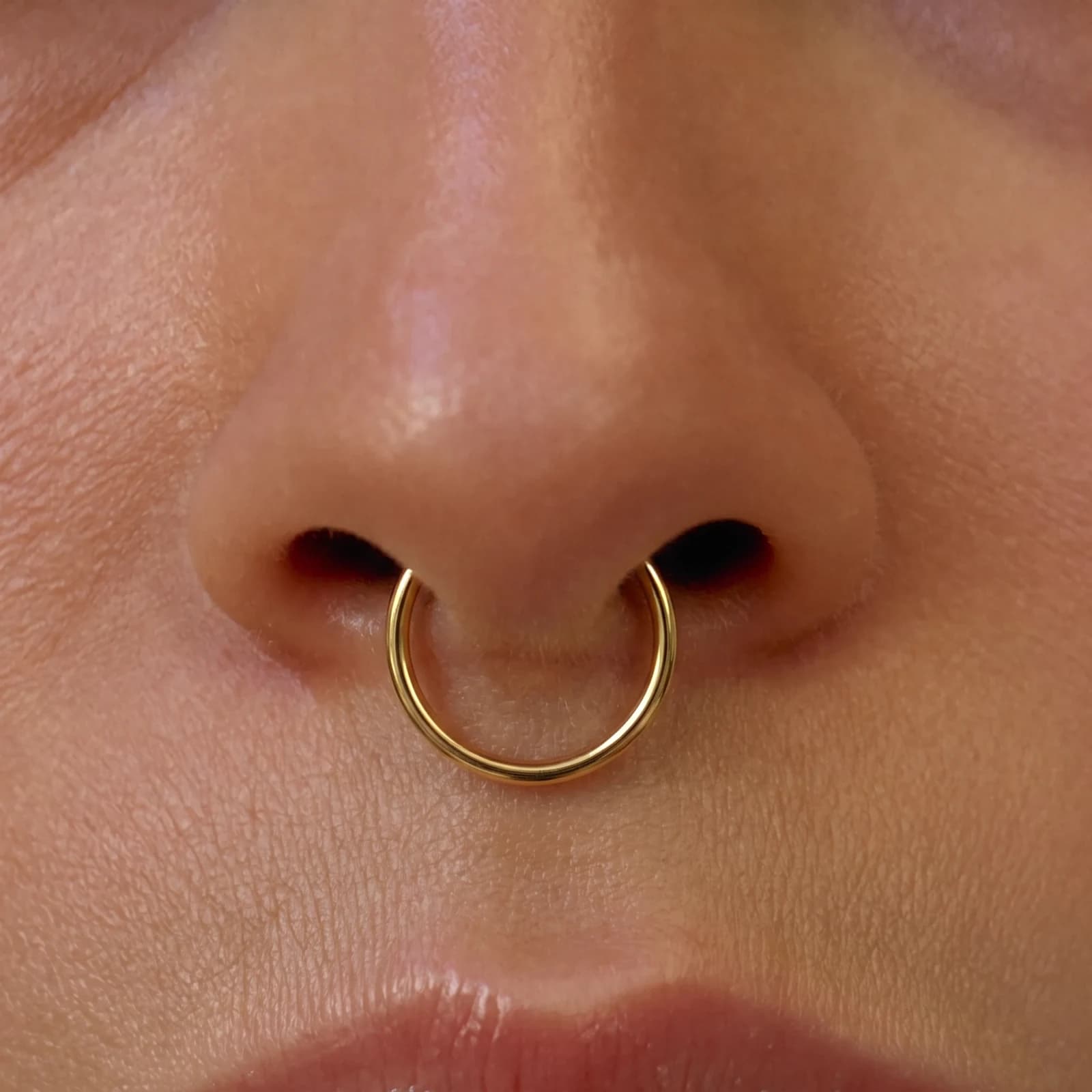 A healed septum piercing with a seamless ring
