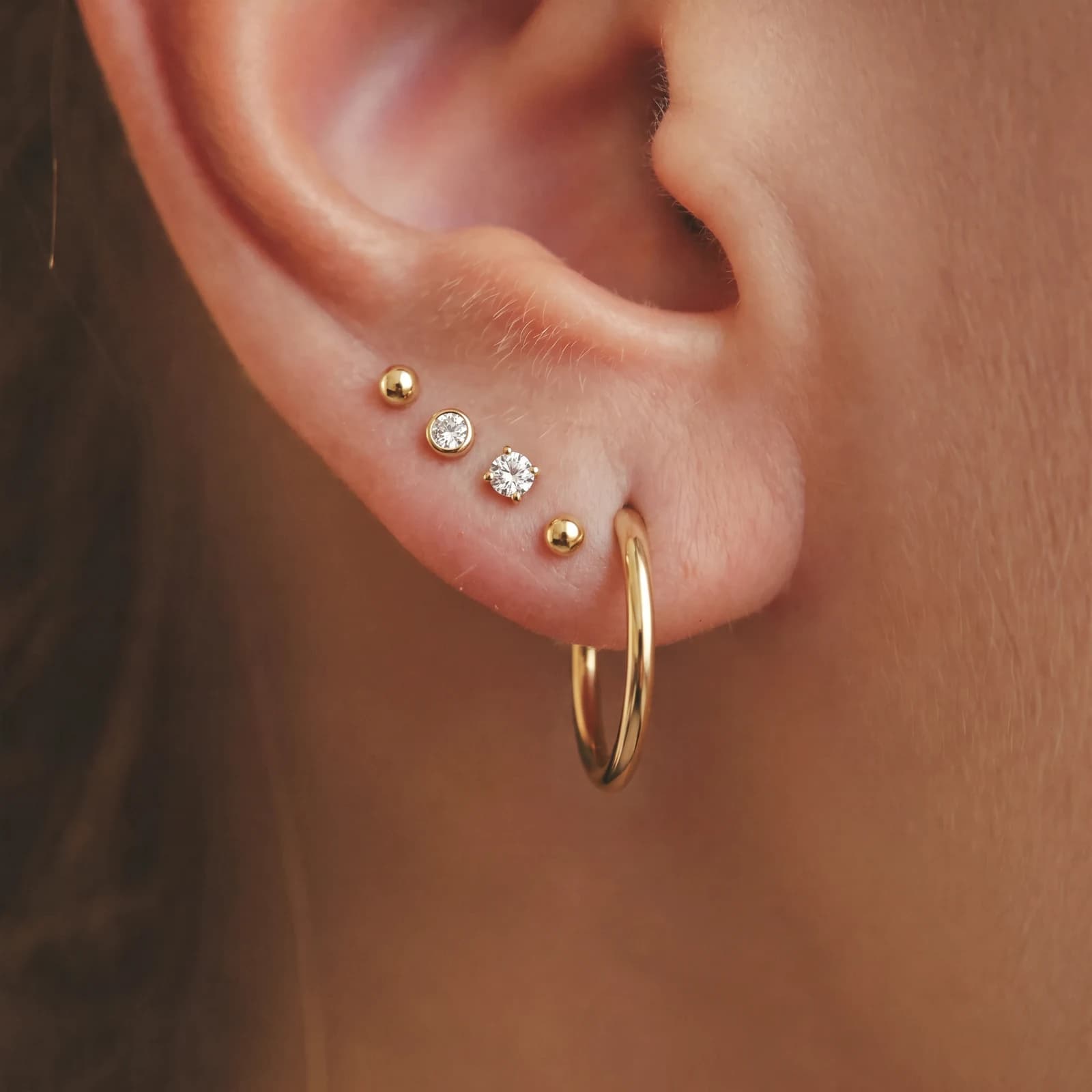 Three small studs grouped on the lobe